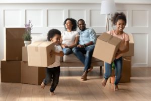 Happy little African American kids holding boxes play on moving day